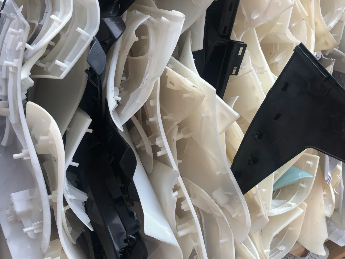 Mixed black and white moulded plastic components ready for recycling