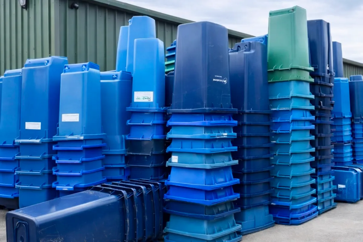 Stacks of blue and green plastic bins and boxes collected for recycling