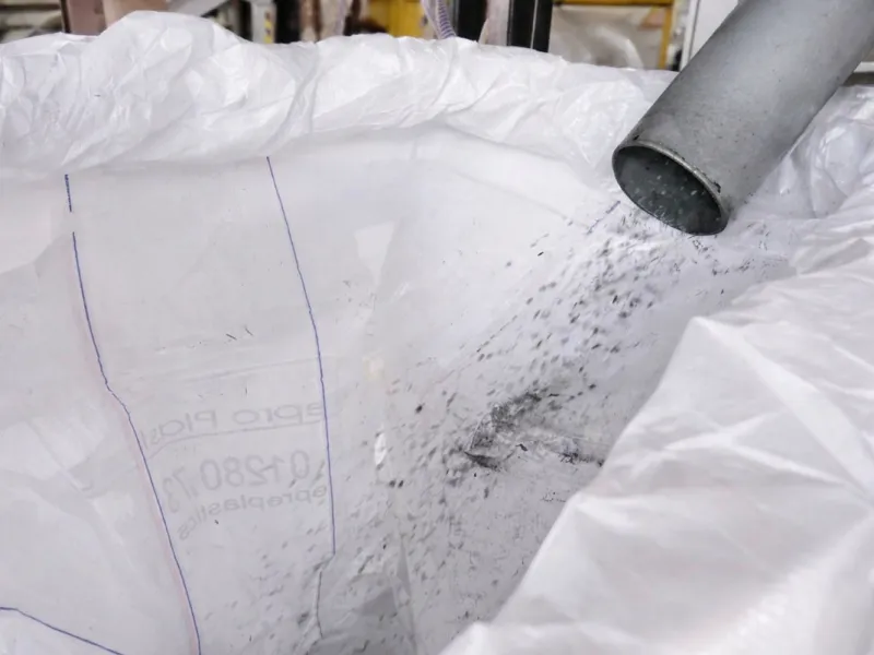 Pipes feeding processed plastic into a white bulk bag